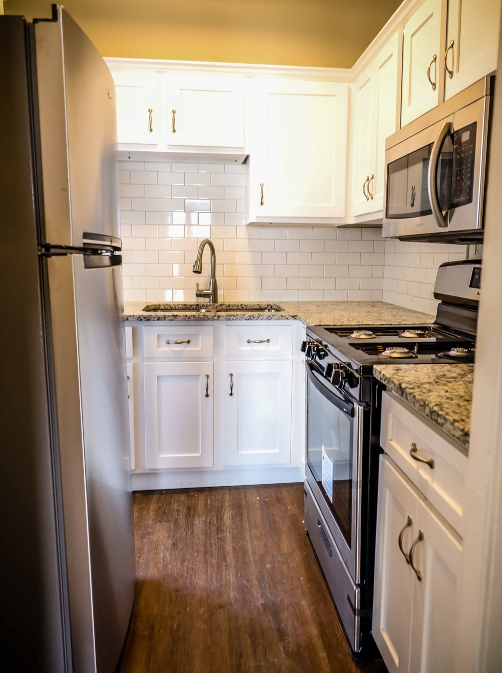 a kitchen with white cabinets and stainless steel appliances