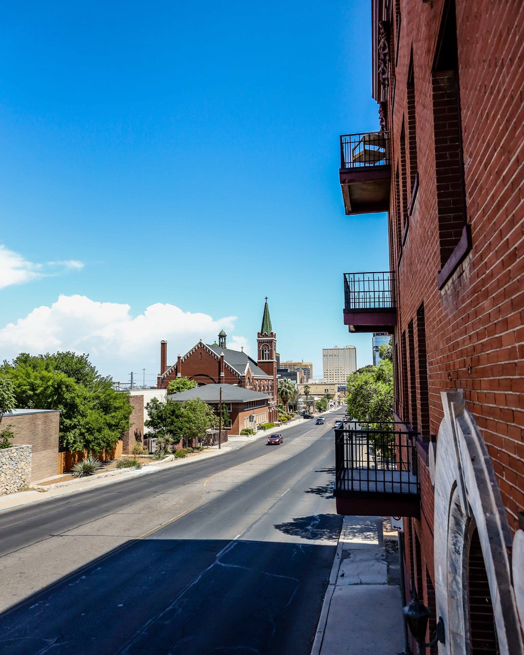 a city street with buildings and a church in the distance