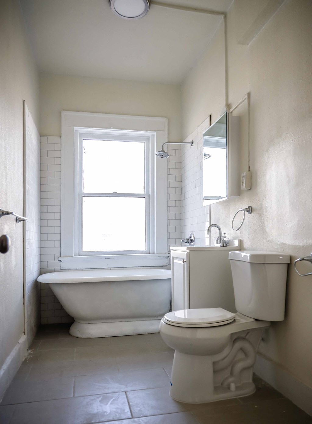 a bathroom with a toilet and a bath tub and a window