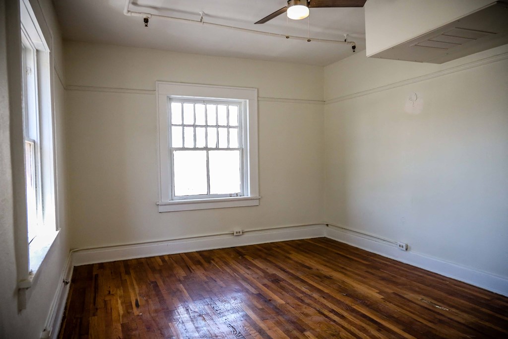 the living room of a house with wood floors and a window