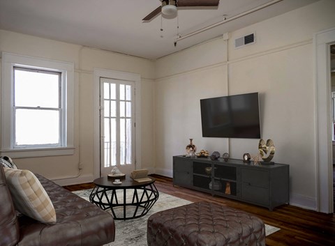 a living room with a leather couch and a television