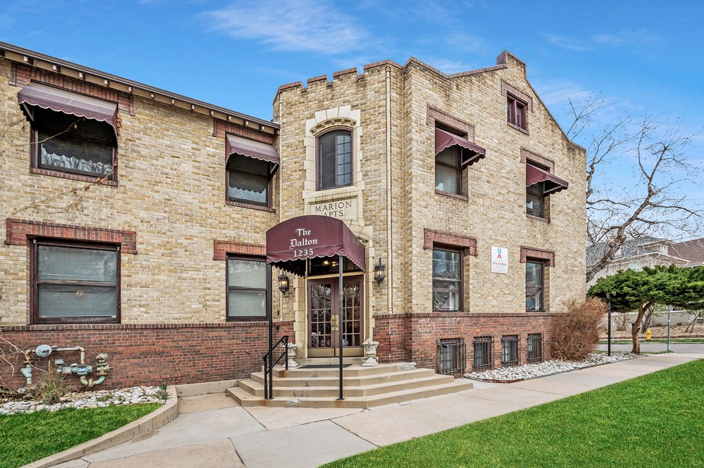 a brick building with a purple awning and a sidewalk