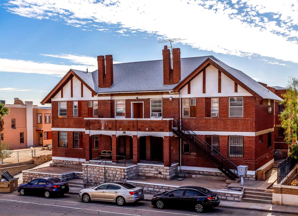 a red brick house with cars parked in front of it