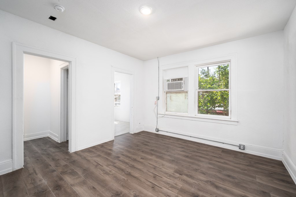 an empty living room with white walls and a window