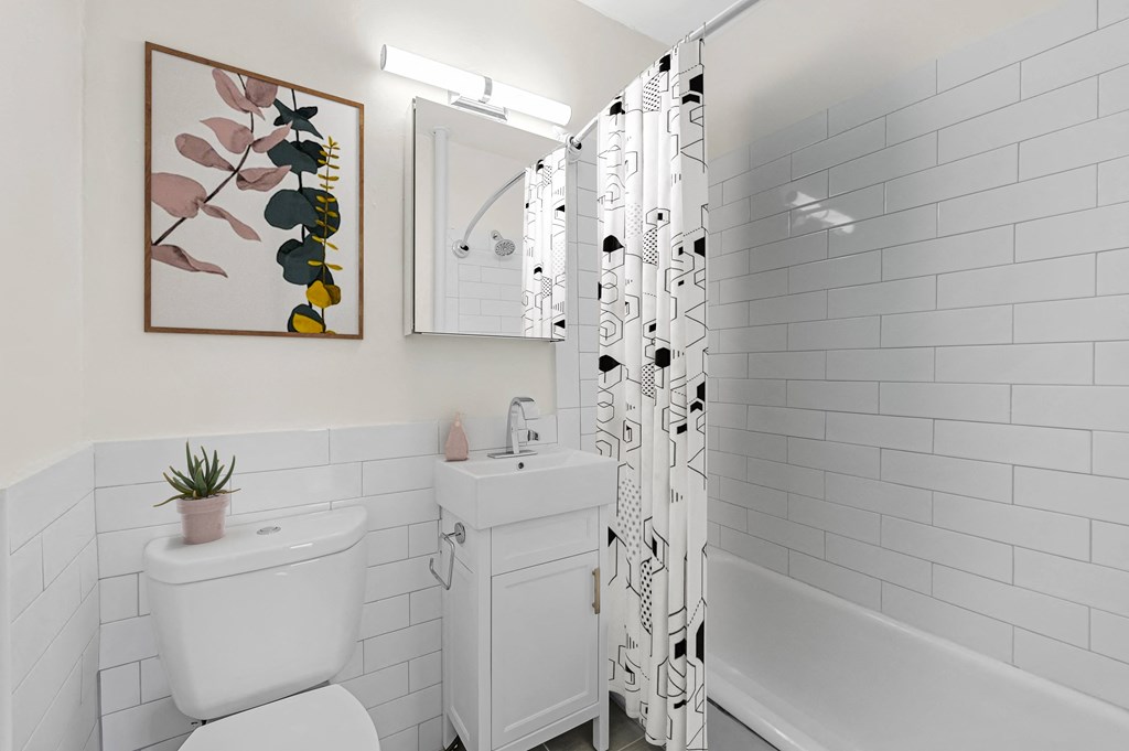 a white bathroom with a black and white shower curtain