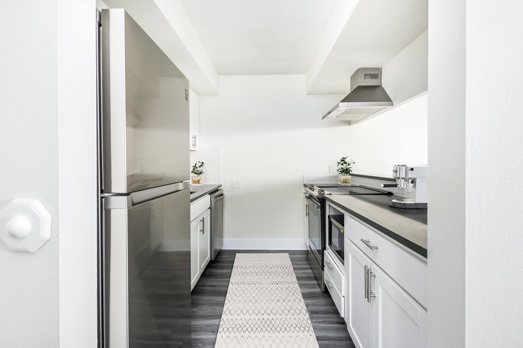 a renovated kitchen with white cabinets and stainless steel appliances