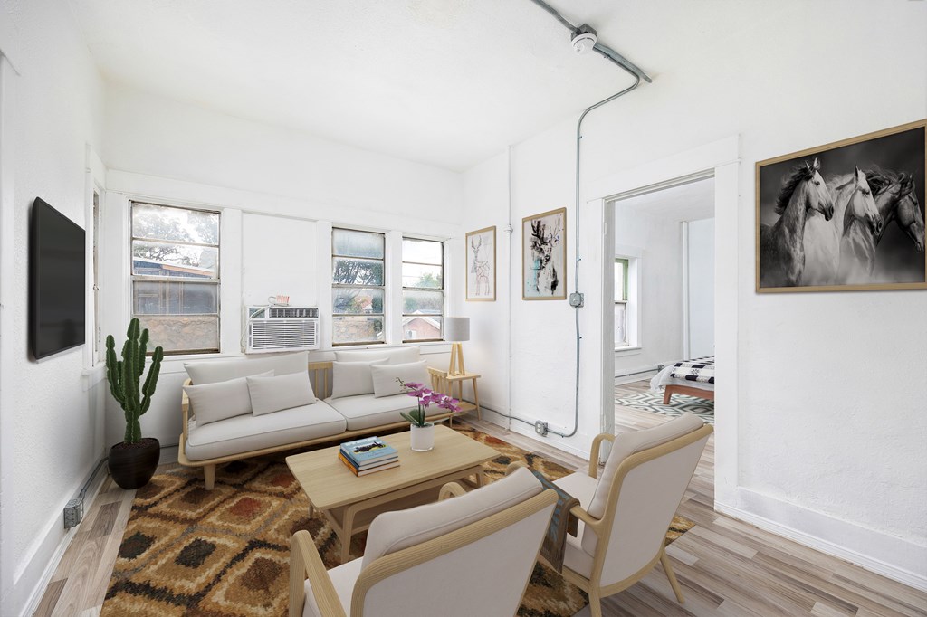 A living room with a couch, a chair, a rug, and a painting on the wall.