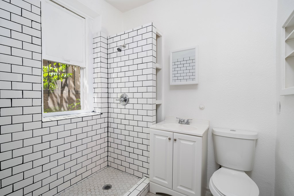 A white bathroom with a toilet and a shower.
