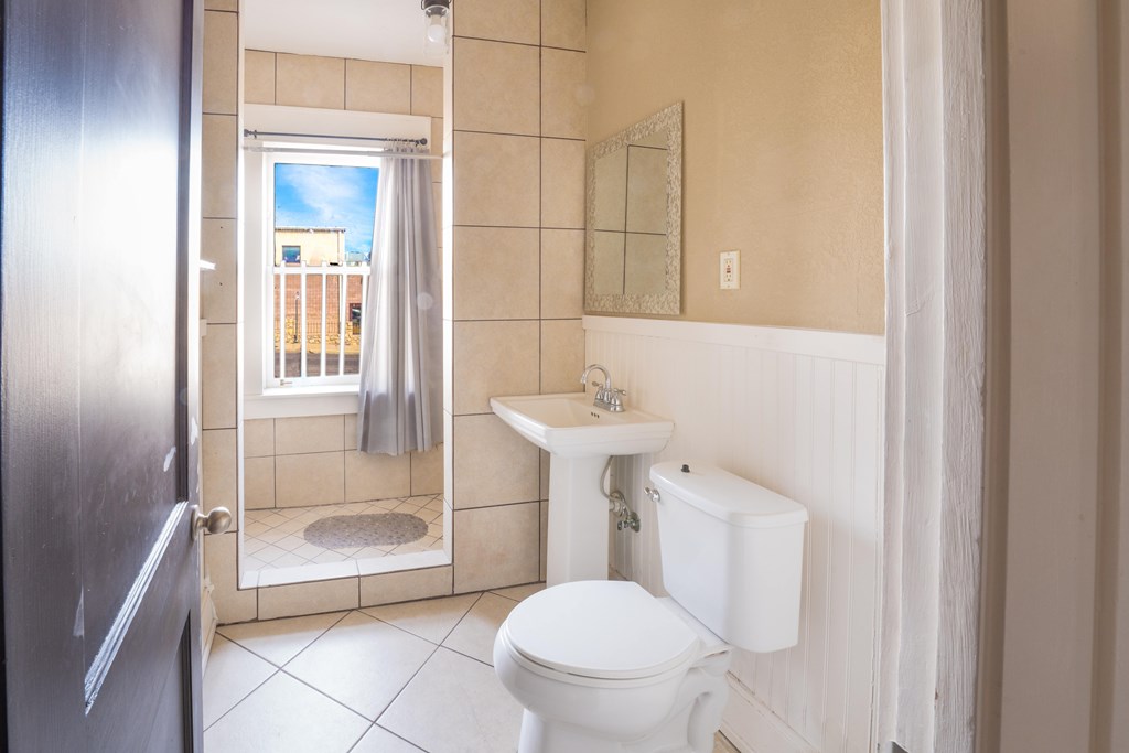 A bathroom with a toilet, sink, and shower.