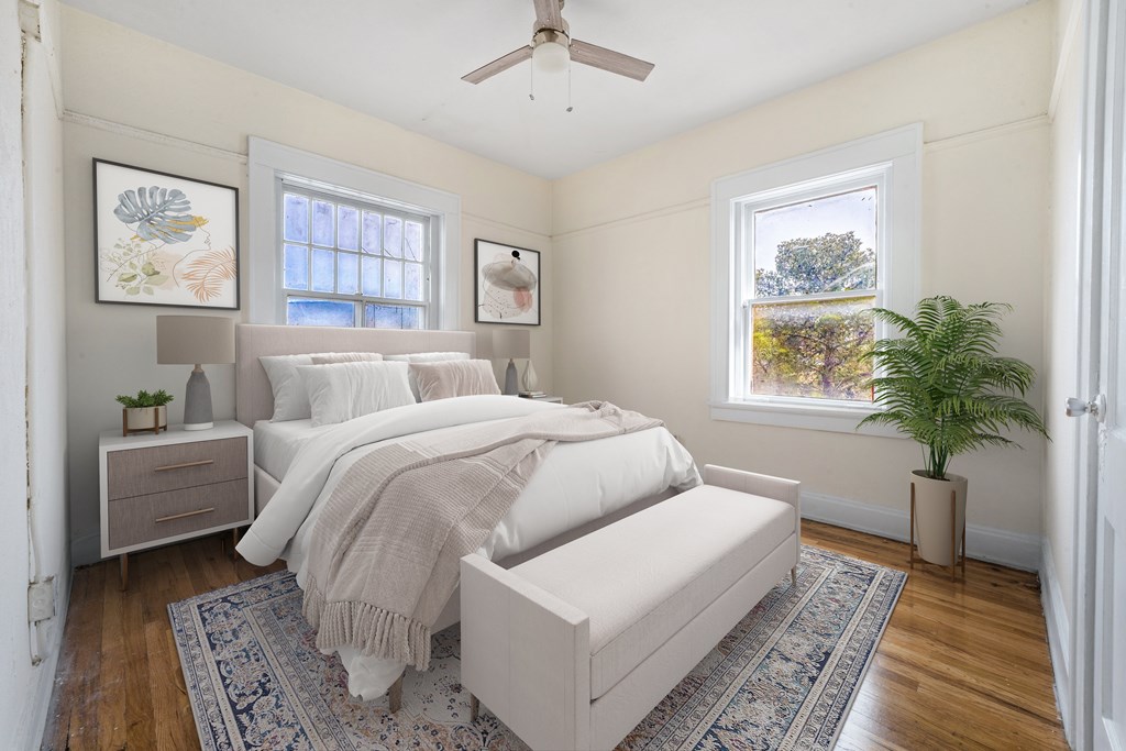 A bedroom with a large bed and a ceiling fan.