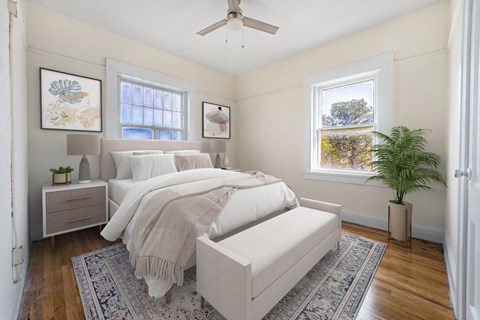 A bedroom with a large bed and a ceiling fan.