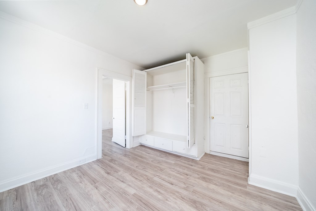 an empty room with white walls and a closet