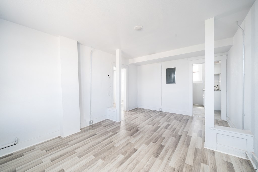 an empty living room with white walls and wood flooring