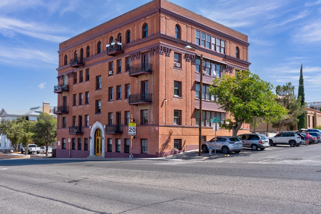 A red brick building with a yellow door and balconies.