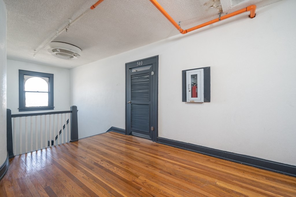 A room with a wooden floor and a window.