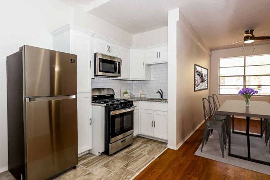 a kitchen with a stainless steel refrigerator and a table