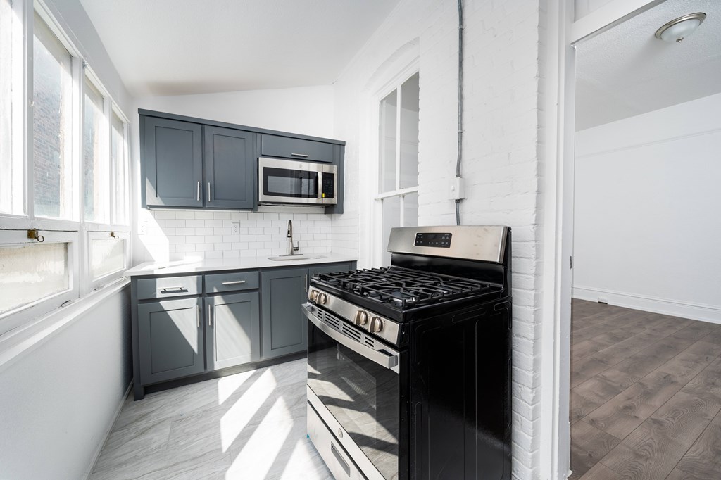 A modern kitchen with a black stove top oven.