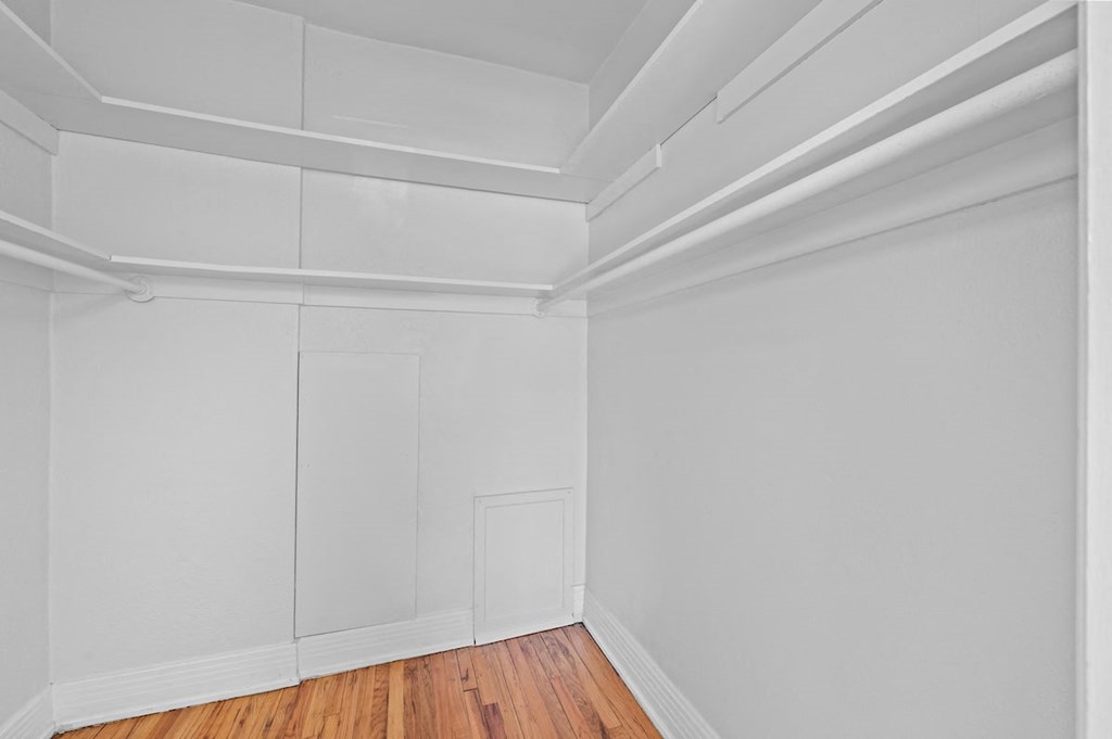 an empty room with white walls and wood floors