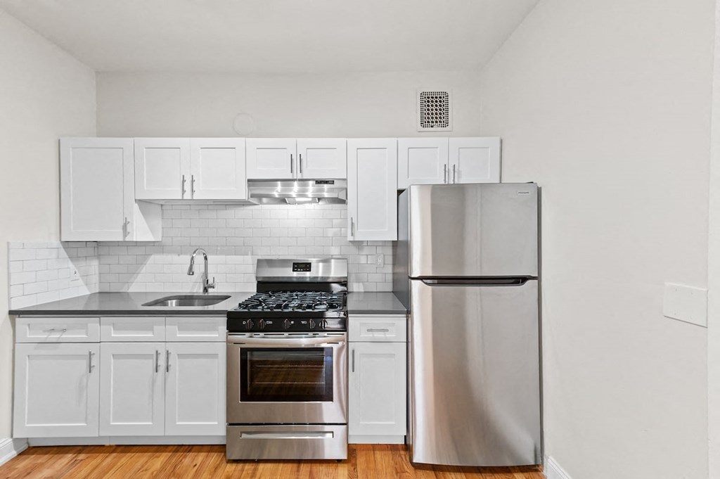 a kitchen with white cabinets and stainless steel appliances