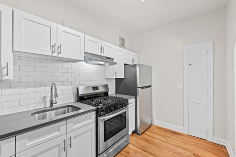 a kitchen with white cabinets and stainless steel appliances