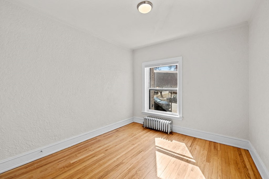 an empty room with wood floors and a window
