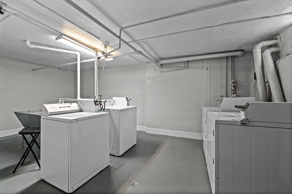 an empty room with washing machines and dryers in it