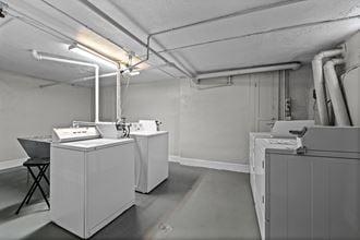 an empty room with washing machines and dryers in it