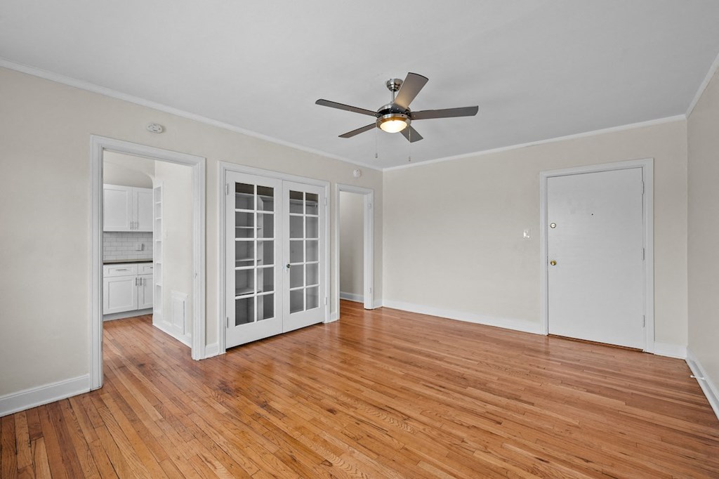 a living room with wood floors and a ceiling fan