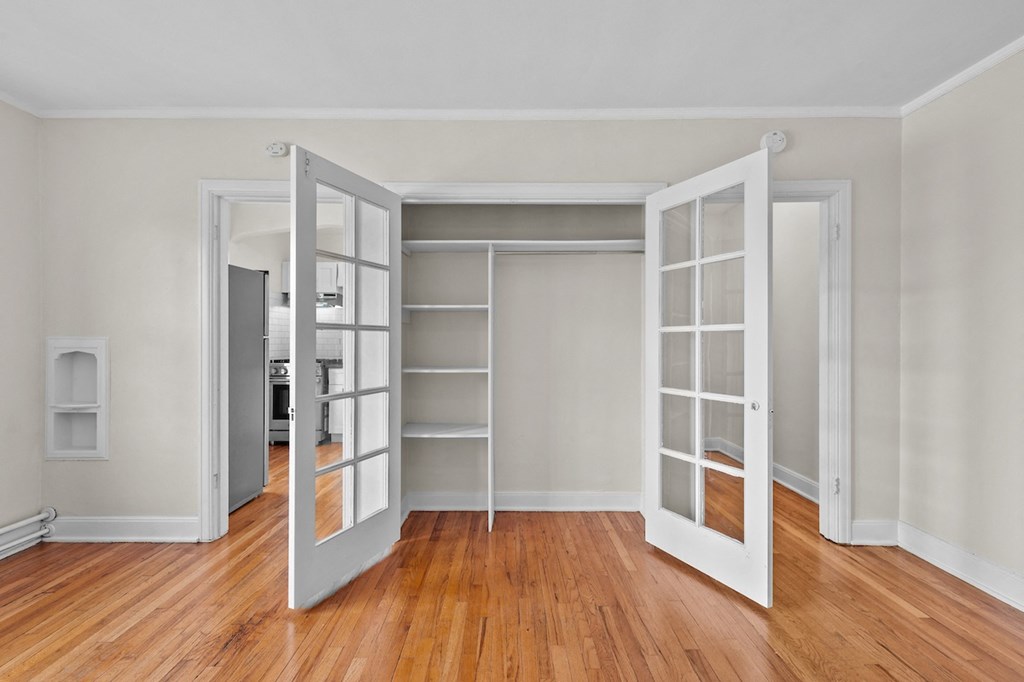 an empty living room with open doors to a closet