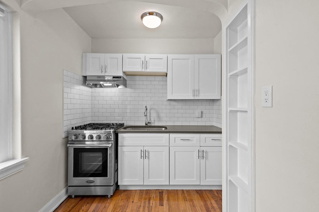 a kitchen with white cabinets and a stove top oven
