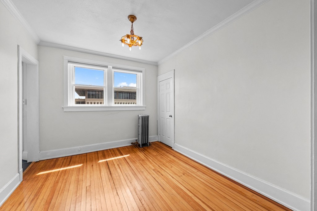 an empty living room with wood floors and a window