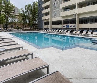 a large swimming pool with benches and a building