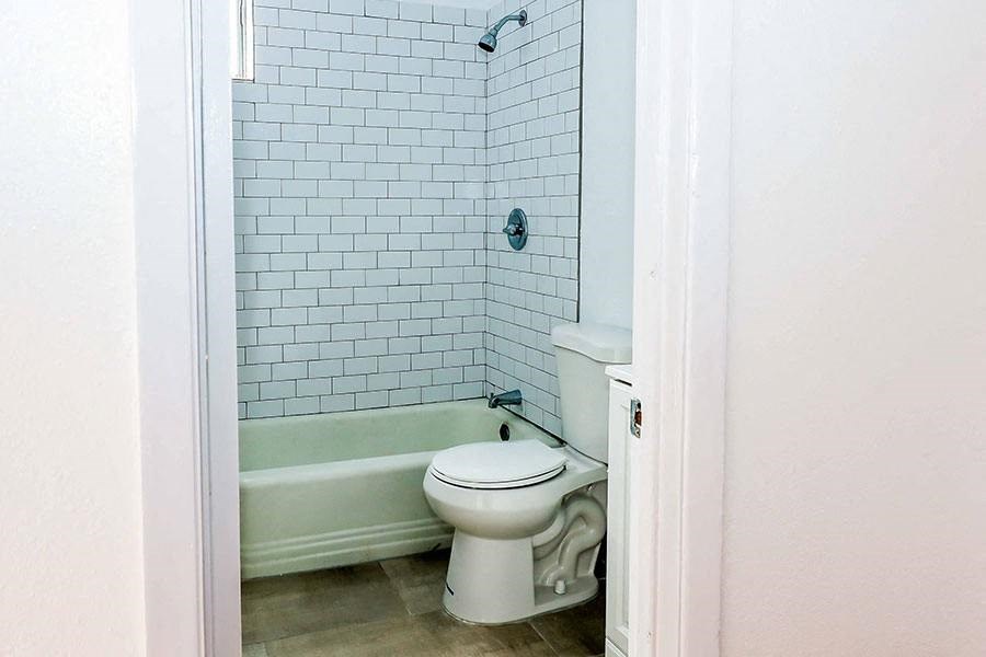 a bathroom with a white toilet and a bath tub