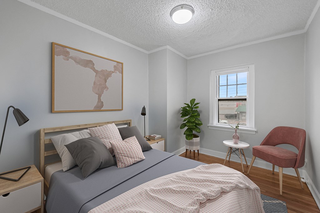 a bedroom with a bed and a chair and a window