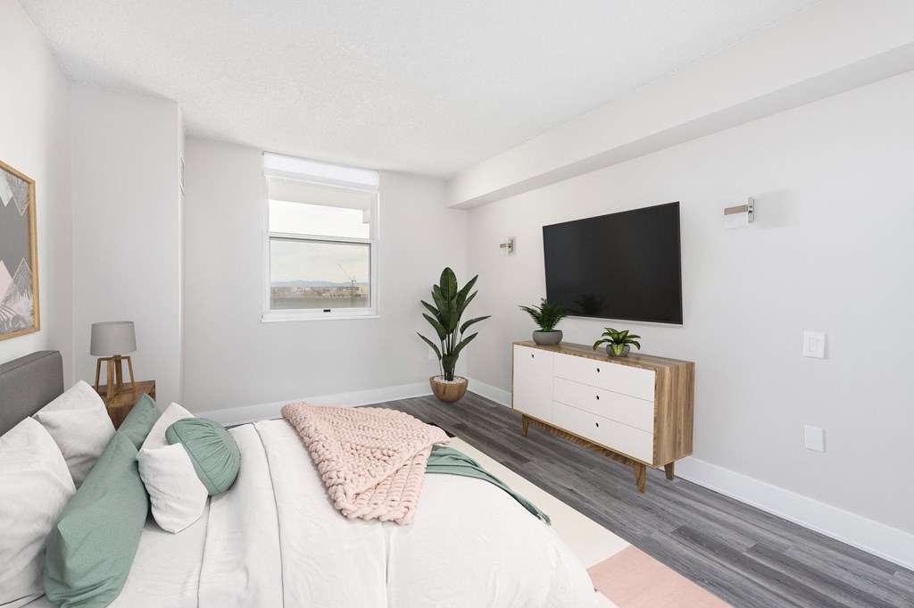 a bedroom with a bed and a tv on the wall