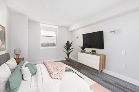 a bedroom with a bed and a tv on the wall