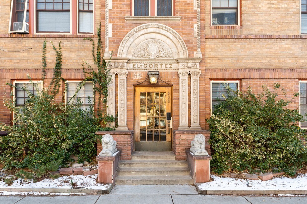 the front of a brick building with snow on the steps