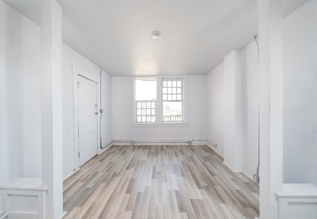an empty room with white walls and a window