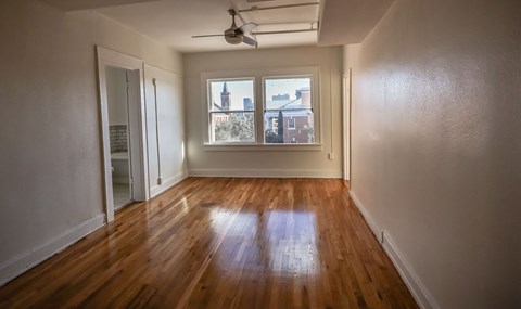 A room with wooden floors and a ceiling fan.
