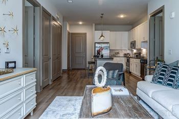A modern kitchen with a dining area and a living room.