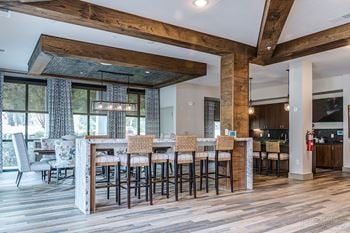 A modern kitchen with a bar area and wooden floors.
