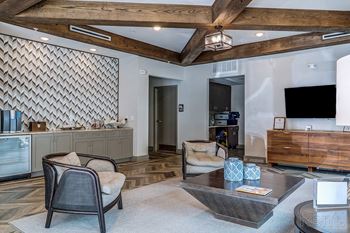 A modern living room with a wooden ceiling and a grey sofa.
