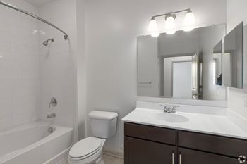 A white bathroom with a toilet, sink, and bathtub.