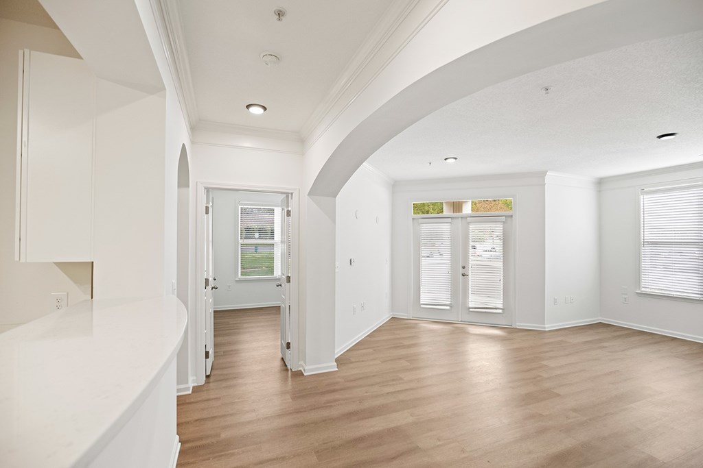 A white interior with wood floors and a window.