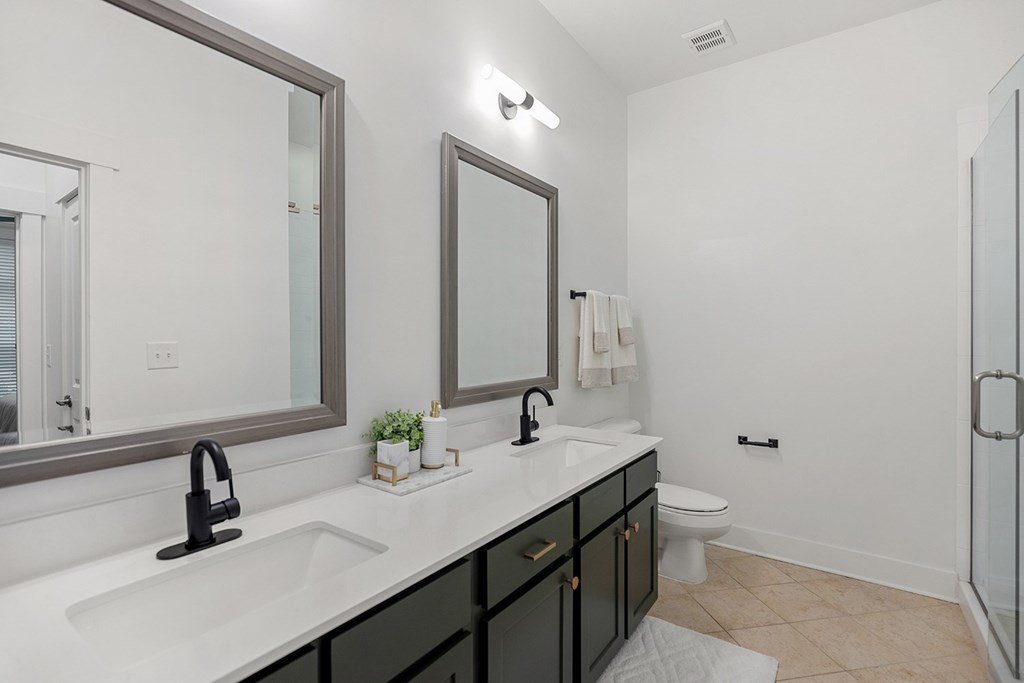 A bathroom with a sink, mirror, and toilet.