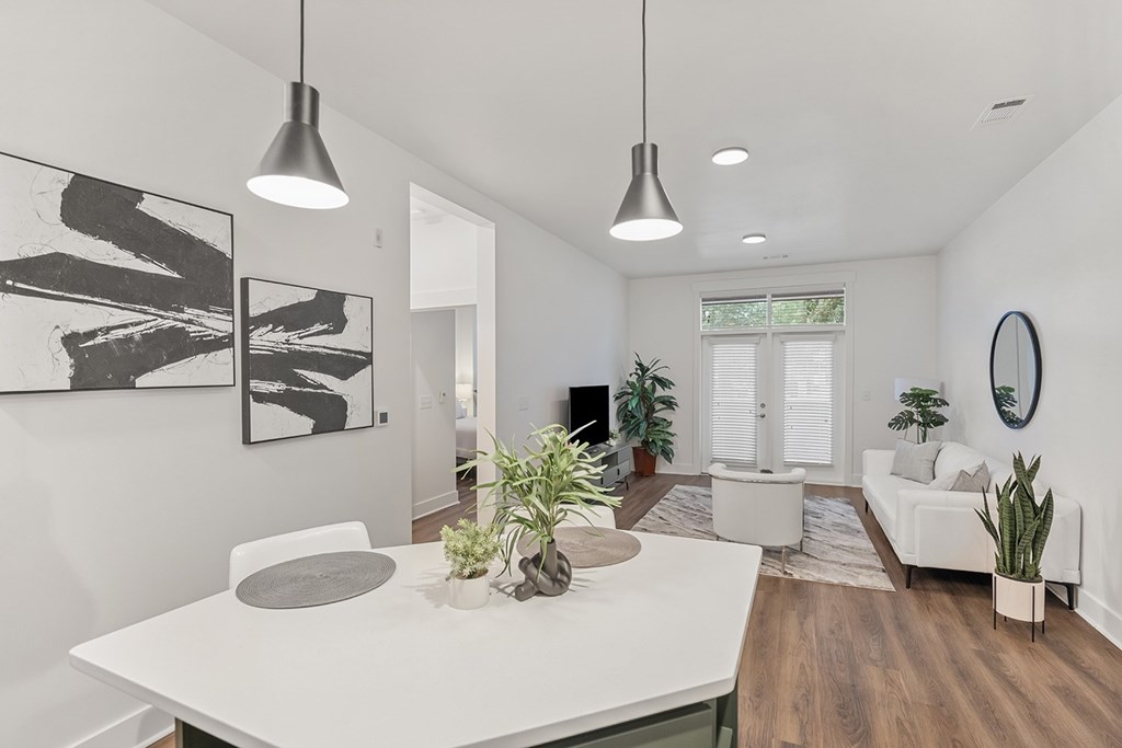 A modern dining room with a white table and chairs.