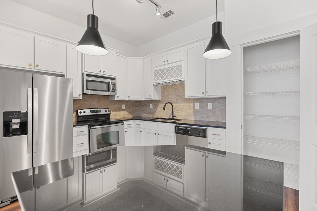 A modern kitchen with stainless steel appliances and white cabinets.