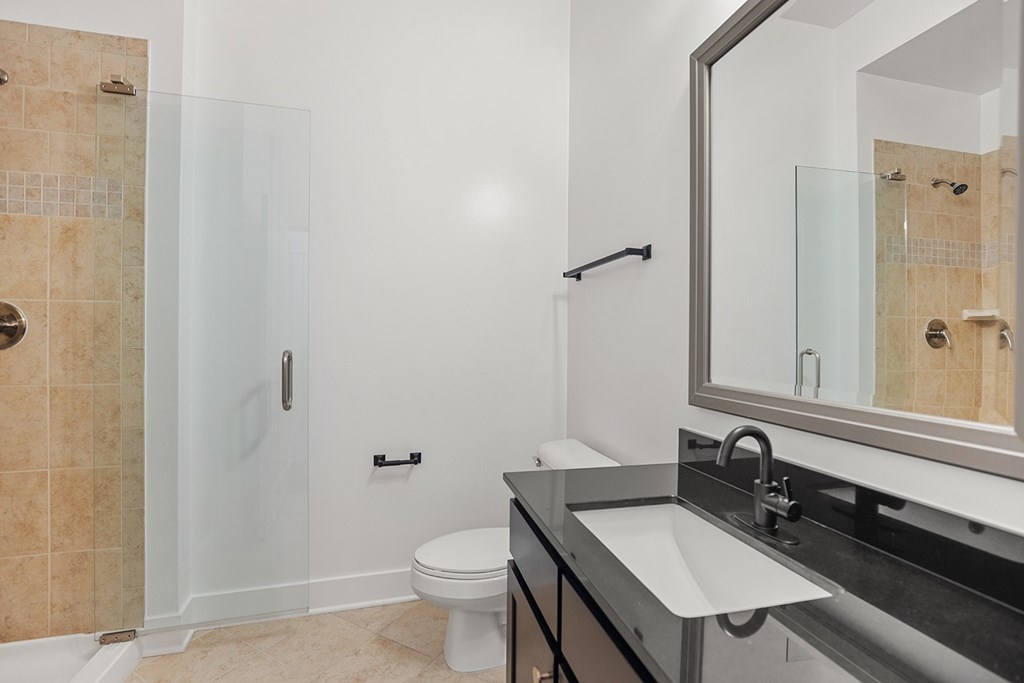 A bathroom with a toilet, sink, and shower.