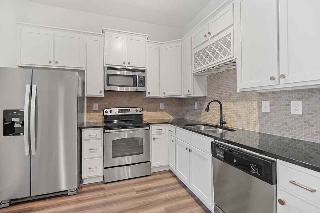 A kitchen with white cabinets and stainless steel appliances.