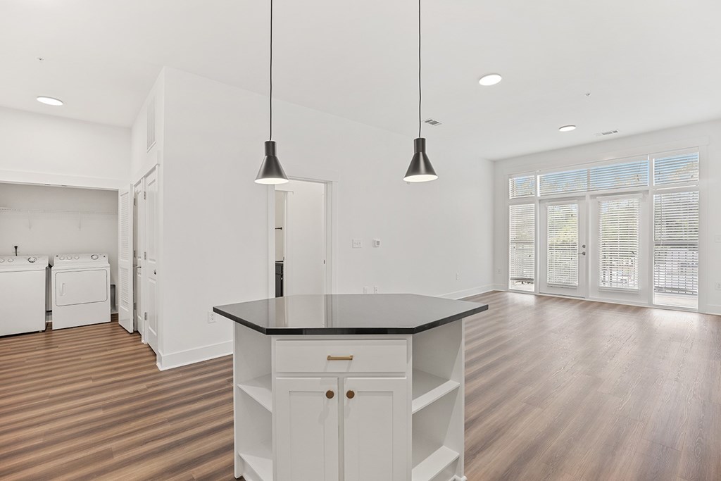 A kitchen with a black countertop and white cabinets.